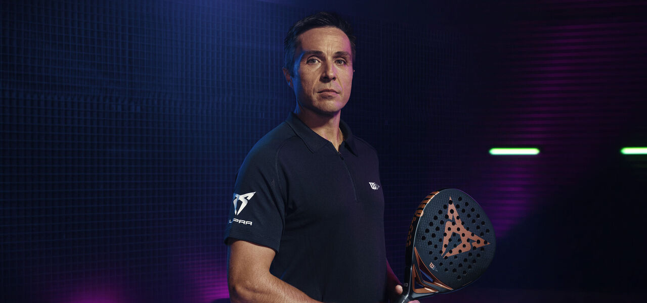 Muž v tričku CUPRA a raketou na padel CUPRA