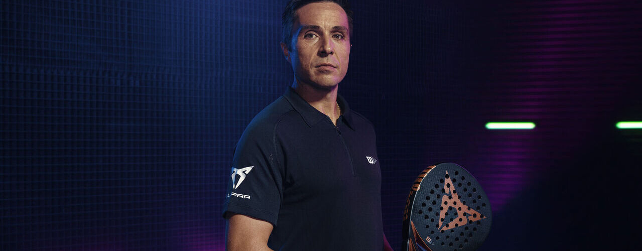 Muž v tričku CUPRA a raketou na padel CUPRA